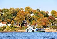 1015_154  Eine Hafenfhre fhrt zum Anleger Oevelgnne / Neumhlen; am Elbstrand sitzen Menschen in der Herbstsonne und blicken auf die Elbe. Die Bume zwischen den Husern zeigen prchtige Herbstfarben. 