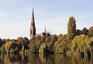 915_9923  Blick ber den Kuhmhlenteich in Hamburg Uhlenhorst zur St. Gertrud-Kirche. Die neugotische Architektur wurde vom Architekten Johannes Otzen entworfen und 1886 fertig gestellt. Am Ufer des Kuhmhlenteichs senken Weiden ihre Zweige tief zum Wasser - das Laub der Bume ist herbstlich gefrbt. 