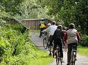 17_21555 Eine Familie macht auf dem Billewanderweg eine Fahrradtour. Eine Holzbrcke fhrt die Fahrradfahrer und Fahrradfahrerinnen ber den Hamburger Fluss.