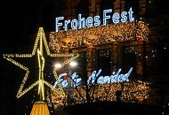 4677_1395 Lichterdekoration zu Weihnachtszeit an einer Hausfassade in der Hamburge Innenstadt. Blaue Leuchtschrift Frohes Fest - Feliz Navidad, darunter Lichterketten, Lichternetze; beleuchteter Weihnachtsstern.