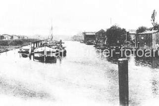 01161_45343 Historisches Foto vom Hafenbecken in  Hamburg Rothenburgsort - Lastkhne liegen an Dalben im Wasser; Gewerbegebude sind direkt an die Wasserseite gebaut / Schiffe werden an der Kainalage entladen. 