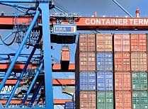 011_86_0140 ber die Containerbrcken wird die Ladung des Schiffs gelscht - hoch oben an der Katze des Auslegers hngt eine der vielen Metallboxen und wird an Land gebracht.