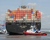 011_57-8029 Das Containerschiff NYK Vesta ist hoch mit Containern beladen - ein Hafenschlepper untersttzt den Frachter bei der Ausfahrt aus dem Hamburer Hafen. Die NYK VETA hat eine Breite von 45,60m und eine Lnge von 338m. Mit 8600 TEU voll beladen hat das Frachtschiff einen Tiefgang von 14,50m und kann bei einer Maschinenleistung von ca. 87000 PS 24,5 kn fahren.  www.hamburg-fotograf.com