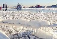 011_79_5688 Die Elbe ist mit Eisschollen dicht bedeckt - am Tau eines Schiffs, das am Ufer festgemacht hat, hngt eine dicke Schicht Eis mit Eiszapfen. Durch das Treibeis fahren zwei Hamburger Hafenfhren.