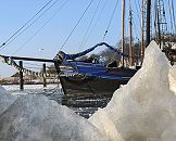 011_26074 Eisschollen am Ufer der Elbe vom Museumshafen Hamburg Oevelgoenne - die Wintersonne scheint auf das Eis. Ein historisches Segelboot liegt an seinem Liegeplatz im Hafen und berwintert dort. Das Wasser der Elbe ist gefroren. www.hamburg-fotograf.com