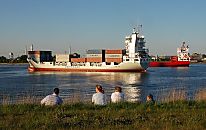 011_15592 zwei Containerschiffe / Containerfeeder liegen auf dem Khlbrand ( Sderelbe ) und warten auf einen Liegeplatz am Terminal Altenwerder. Hamburg Touristen sitzen in der Abendsonne auf dem Elbdeich und beobachten den Schiffsverkehr.