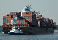 011_26036  Schlepper bringen einen Containerriesen aus dem Hamburger Hafen in die Fahrtrinne der Elbe; das Containerschiff ist hoch mit den grossen Metallboxen beladen.   www.christoph-bellin.de