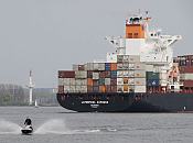 011_26058  Das Containerschiff LIVERPOOL EXPRESS mit dem Heimathafen Hamburg fhrt vor Wedel Richtung Hamburger Hafen. Der Containerfrachter der Reederei HAPAG LLOYD gehrt zur Dublin Klasse und hat eine Gesamtlnge von 282m und eine Breite von 32,20m - der Fachter kann 4.115 TEU / Standartcontainer an Bord nehmen. Im Vordergrund fhrt ein Jetski / Wassermotorrad in voller Fahrt, so dass die Gischt hoch aufspritzt.  www.christoph-bellin.de