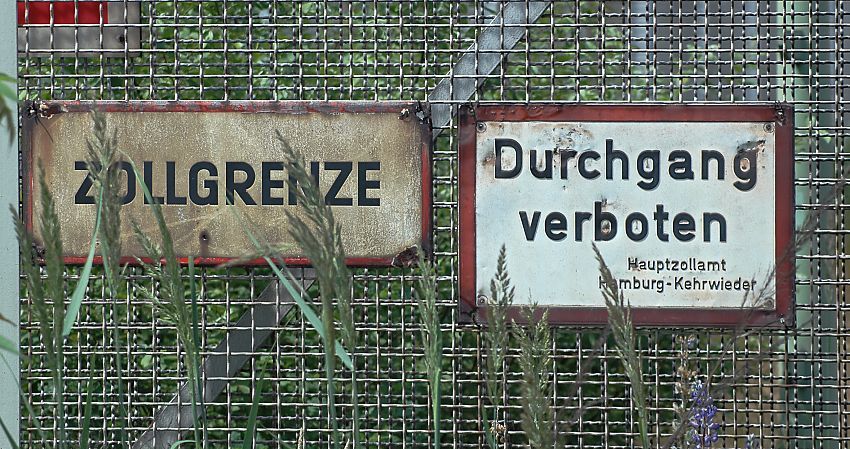 017_19013 Hamburgs Fotos: zwei alte Schilder, die fast von hohem Gras verdeckt werden; sie weisen auf die Zollgrenze hin und "Durchgang verboten - Hauptzollamt Kehrwieder."   www.christoph-bellin.de