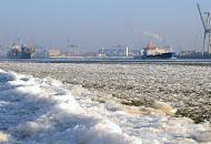3133 Schiffsverkehr zwischen Eisschollen auf der Elbe - zwei Frachtschiffe laufen aus dem Hamburger Hafen aus; die Elbe ist dicht mit Eis bedeckt - im Hintergrund die Mndung der Sderelbe / Khlbrand in die Norderelbe. Der Elbstrand ist dicht mit einer Eisschicht bedeckt.
