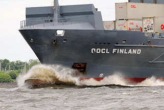 8932 Frachtschiff OOCL FINLAND in Fahrt auf der Elbe - Gischt schumt am Schiffsbug.