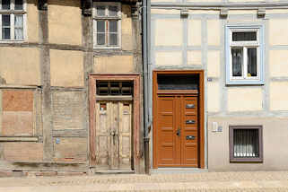 270_3536 Alt + Neu, restauriertes Fachwerkhaus mit blau abgesetzten Fenstern und Fachwerkbalken, neue Holztür mit Briefkästen - altes FAchwerkhaus mit  vernagelten Fenster und alter Holztür, abgeblätterte Farbe. Architektur in Halberstadt.