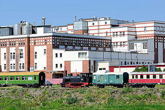 4017 Industriearchitektur im Magdeburger Hafengebiet - Ziegelgebäude mit weiss abgesetzter Fassade der 1930er Jahre - historische Eisenbahnwaggons, Lokomotive.