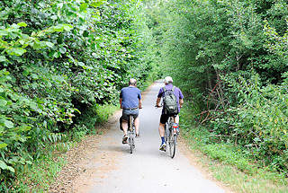 1270 Radweg am Rande des Heidkoppelmoors in Hoiesbüttel / Ammersbek - zwei Radfahrer bei einer Radtour durch das Naturschutzgebiet.